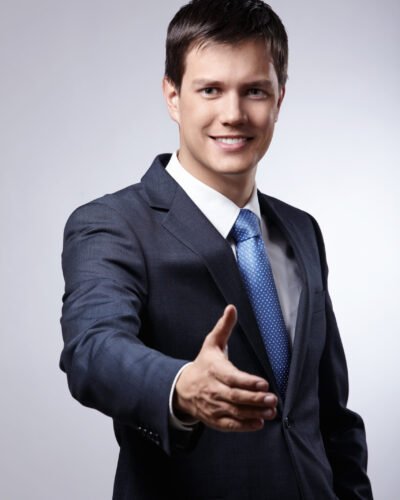 Young businessman in a suit holds out his hand for a handshake